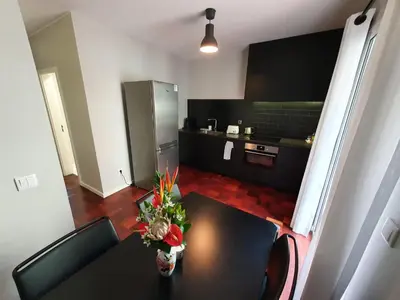 a living room with a table and a kitchen at Santa Luzia's Pearl II E - One Bedroom Apartment in Funchal