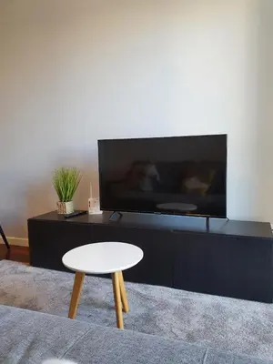 a living room with a white table and a tv at Santa Luzia's Pearl II E - One Bedroom Apartment in Funchal