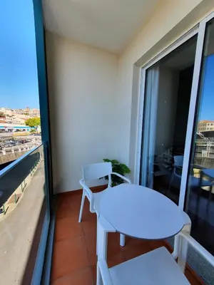 a white table and chairs on a balcony with a view at Santa Luzia's Pearl II E - One Bedroom Apartment in Funchal