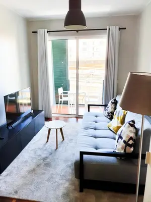 a living room with a blue couch and a tv at Santa Luzia's Pearl II E - One Bedroom Apartment in Funchal