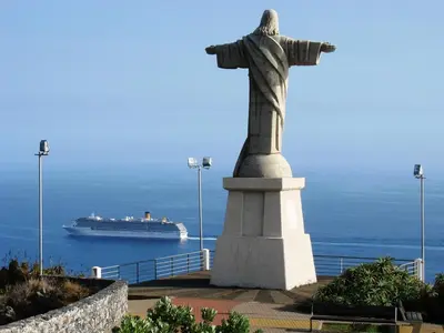 a statue of christ the redeemer in front of a cruise ship at Villa Isabela - Car Rental for Free in Caniço