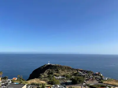 a lighthouse on top of a hill with the ocean at Villa Isabela - Car Rental for Free in Caniço