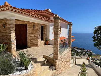 a stone house with a view of the ocean at Villa Isabela - Car Rental for Free in Caniço
