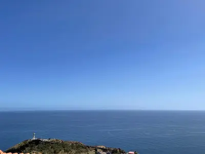 an island in the ocean with a lighthouse on it at Villa Isabela - Car Rental for Free in Caniço