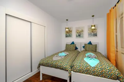 a bedroom with a bed with blue bows on it at Casa Maravilha III in Caniço