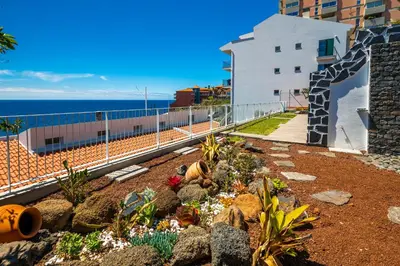 a garden with rocks and flowers in front of a building at Casa Maravilha III in Caniço