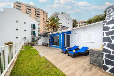 a large deck with blue chairs on top of a building at Casa Maravilha III in Caniço
