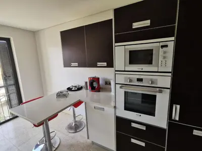 a kitchen with a table and a microwave at Sun Island Apartments in Funchal