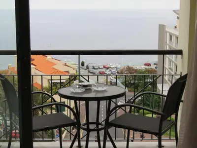 a table and chairs on a balcony with a view at Sun Island Apartments in Funchal