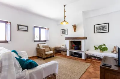 a living room with a couch and a fireplace at Townhouse Sagres in Sagres