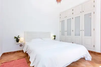 a white bedroom with a white bed and white cabinets at Townhouse Sagres in Sagres