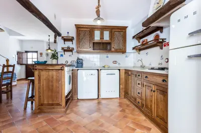 a large kitchen with wooden cabinets and white appliances at Townhouse Sagres in Sagres