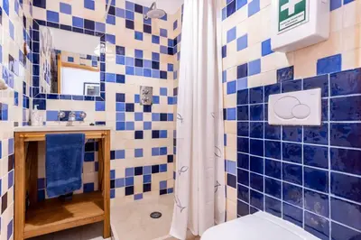 a blue and white tiled bathroom with a shower at Townhouse Sagres in Sagres