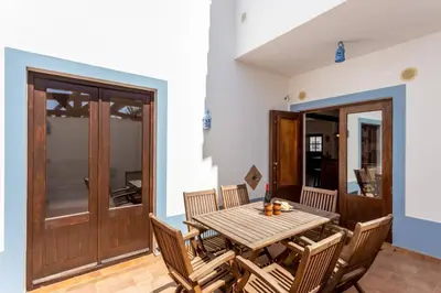 a dining room with a wooden table and chairs at Townhouse Sagres in Sagres
