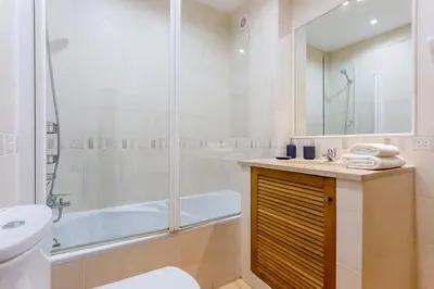 a bathroom with a shower and a tub and a sink at Seaview apartment - Estrela da Luz**** in Luz