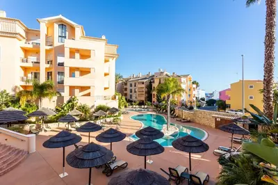 an outdoor patio with umbrellas and a swimming pool at Seaview apartment - Estrela da Luz**** in Luz