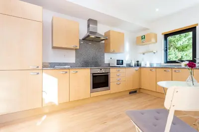 a kitchen with wooden cabinets and a table and a window at Seaview apartment - Estrela da Luz**** in Luz