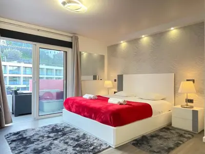 a bedroom with a large bed with a red blanket at Sea and Sun 4 You - Horizonte Azul in Porto Moniz