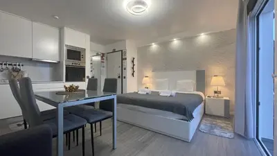 a bedroom with a bed and a table and a kitchen at Sea and Sun 4 You - Horizonte Azul in Porto Moniz