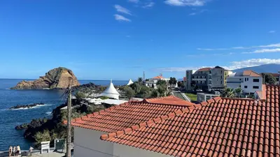 a view of a city with red roofs and the ocean at Sea and Sun 4 You - Horizonte Azul in Porto Moniz