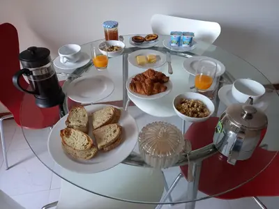 a glass table topped with plates of breakfast foods at La Suite Calypso in Luz