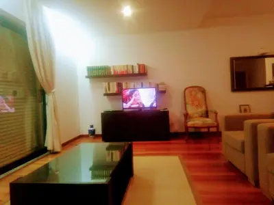 a living room with a tv and a couch at La Suite Calypso in Luz
