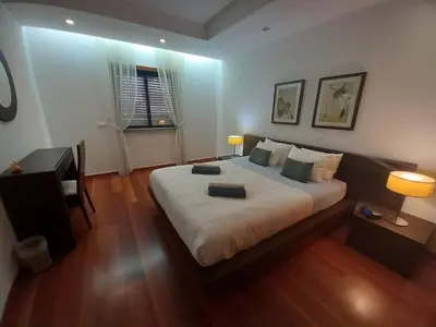 a bedroom with a large white bed with two lamps at La Suite Calypso in Luz