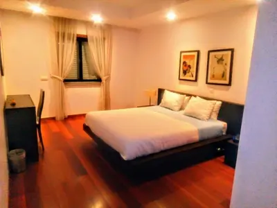a bedroom with a bed and a table and a window at La Suite Calypso in Luz