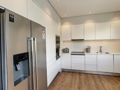 a kitchen with white cabinets and a stainless steel refrigerator at Paradise Apartment by LovelyStay in Funchal
