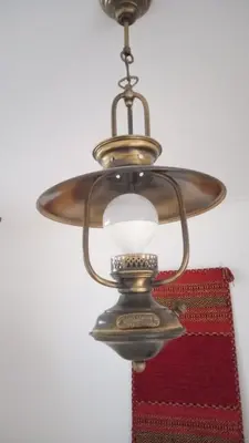 an old fashioned lamp hanging from a ceiling at Lazy Lizard by the Ocean in Seixal