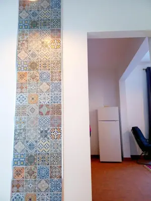 a room with a tile wall and a refrigerator at Lazy Lizard by the Ocean in Seixal