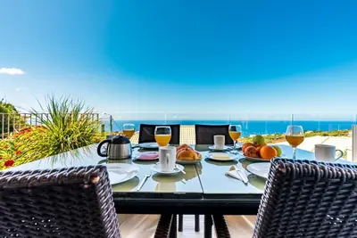 a table with food and wine on the beach at Villa Pinheira IV -Heated swimming pool in Calheta