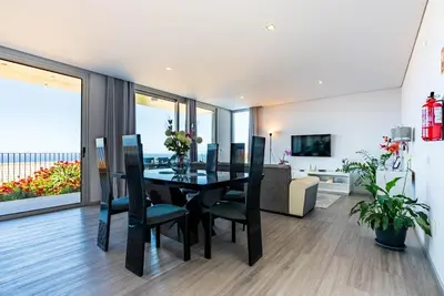 a dining room with a black table and chairs at Villa Pinheira IV -Heated swimming pool in Calheta