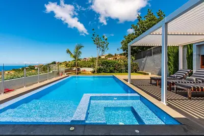 a swimming pool on the balcony of a house at Villa Pinheira IV -Heated swimming pool in Calheta