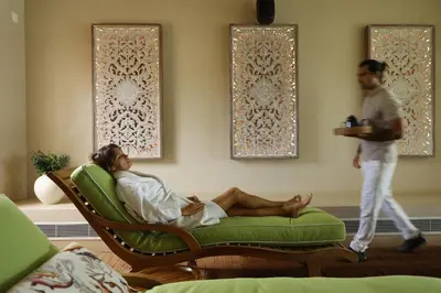 a woman laying on a couch in a room with a man at Praia do Canal Nature Retreat - Small Luxury Hotels of the World in Aljezur