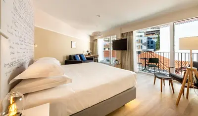 a bedroom with a large bed and a balcony at Pestana Fisherman Village in Câmara de Lobos