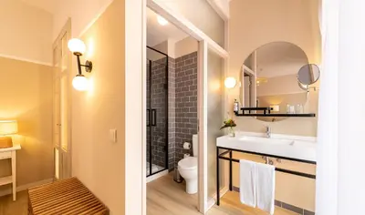 a bathroom with a sink and a toilet and a mirror at Pestana Fisherman Village in Câmara de Lobos