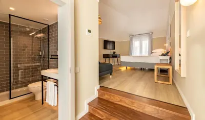 a bathroom with a shower and a bedroom with a bed at Pestana Fisherman Village in Câmara de Lobos