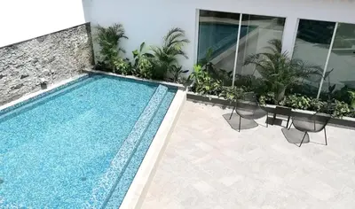 a swimming pool with chairs next to a building at Pestana Fisherman Village in Câmara de Lobos