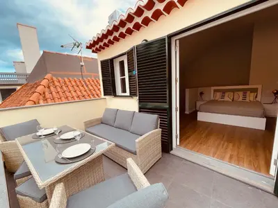 a patio with a table and chairs and a bed at Living Funchal Apartments in Funchal