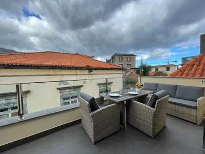a patio with a table and chairs on a balcony at Living Funchal Apartments in Funchal
