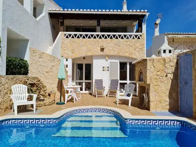 a villa with a swimming pool in front of a house at REFÚGIO DO CARANGUEJO - Praia da Luz - WiFi, Private Pool & BBQ in Luz