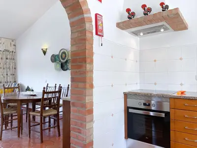 a kitchen and dining room with an archway in the wall at REFÚGIO DO CARANGUEJO - Praia da Luz - WiFi, Private Pool & BBQ in Luz