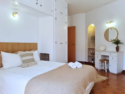 a bedroom with a large bed with two towels on it at REFÚGIO DO CARANGUEJO - Praia da Luz - WiFi, Private Pool & BBQ in Luz