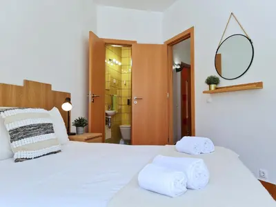 a bedroom with a white bed with towels on it at REFÚGIO DO CARANGUEJO - Praia da Luz - WiFi, Private Pool & BBQ in Luz