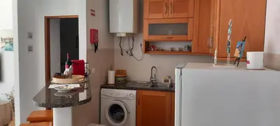 a small kitchen with a sink and a washing machine at Salema Beach Apartment in Salema