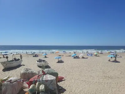a group of people on a beach with umbrellas at Salema Beach Apartment in Salema