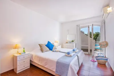a white bedroom with a bed and a window at Villa Cinco by Villa Plus in Luz