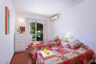a bedroom with two beds and a window at Villa Cinco by Villa Plus in Luz