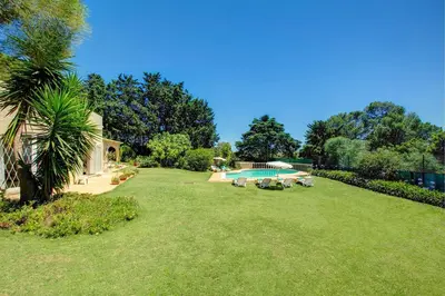 a large yard with a swimming pool and a palm tree at Villa Sounia by Villa Plus in Lagos